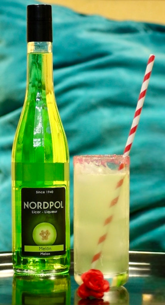 Frankenstein Blood Cocktail mit rotem Zuckerrand und Strohhalm, daneben eine Flasche Nordpol Melonenlikör.