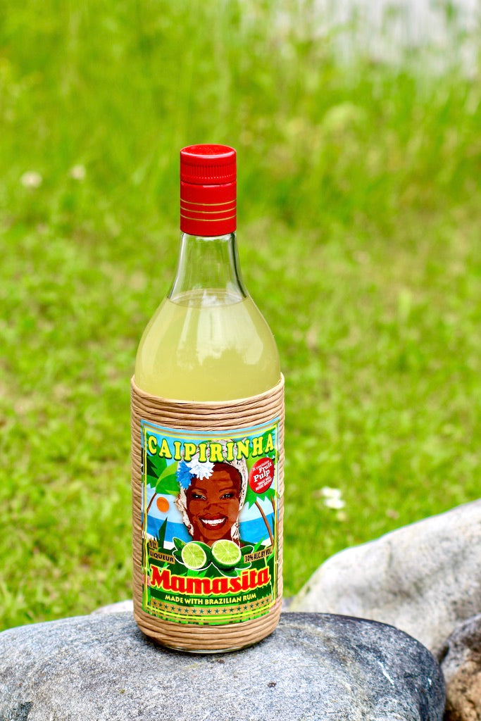 Mamasita Caipirinha Mix Flasche auf Stein vor grünem Wiesenhintergrund