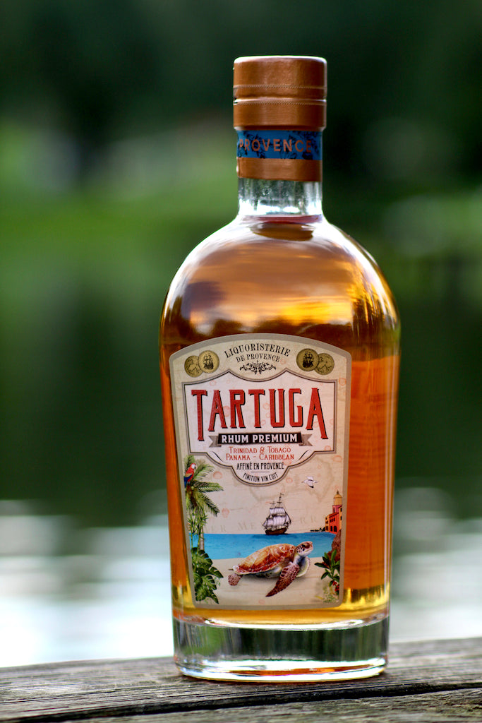 Tartuga Rumflasche auf Holzoberfläche mit grünem Hintergrund und maritimem Etikett