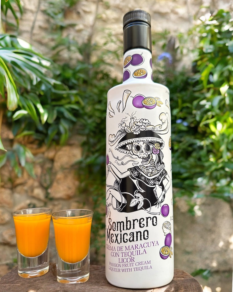 Flasche Sombrero Mexicano Maracuja-Tequila-Likör mit Totenkopf-Design, dekoriert mit Passionsfrüchten, neben zwei Shotgläsern.