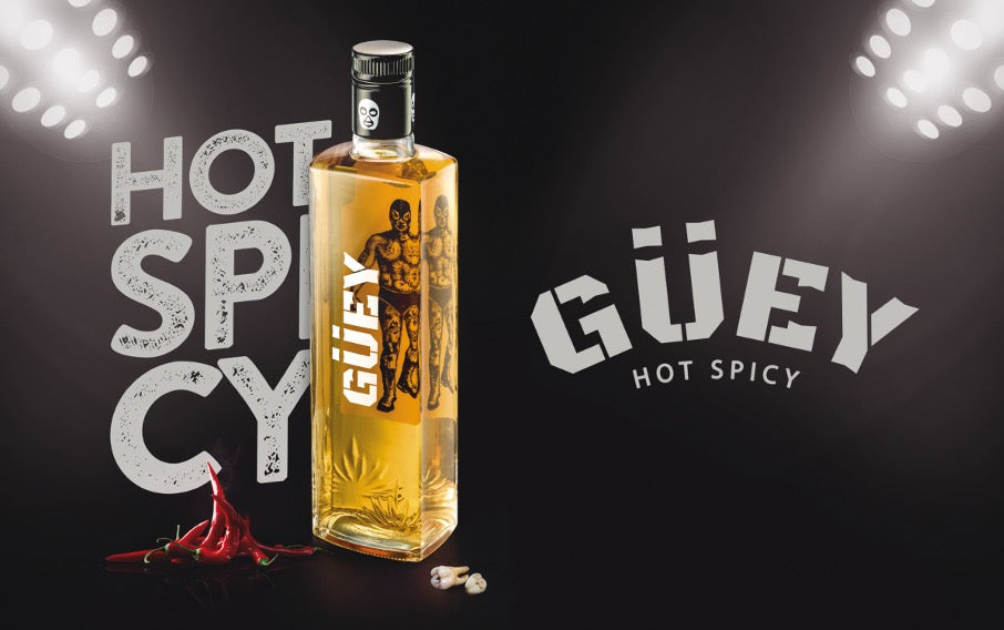 Ein auffälliges Bild der Güey Hot Spicy Tequila-Flasche, begleitet von Chilis und stilvollen Lichteffekten, unterstreicht die Botschaft "Hot Spicy".