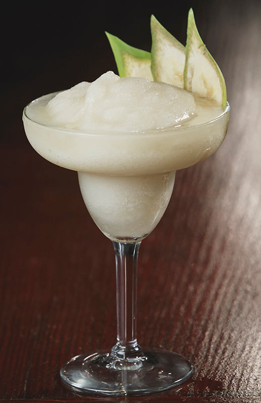 Banana-Gum-Tini Cocktail in einer Margarita-Schale mit gefrorener Konsistenz, garniert mit getrockneten Bananenscheiben.