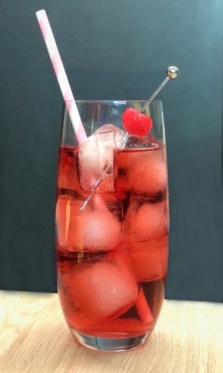 Canadian Princess Cocktail im Highball-Glas mit Eis, Strohhalm und Cocktailkirsche vor dunklem Hintergrund