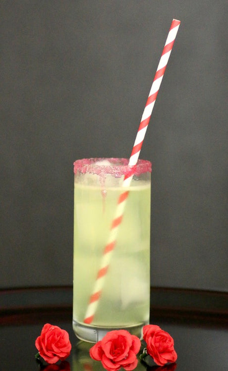 Frankenstein Blood Halloween Cocktail mit Gin und Melonenlikör, blutrotem Zuckerrand und rot-weißem Strohhalm.