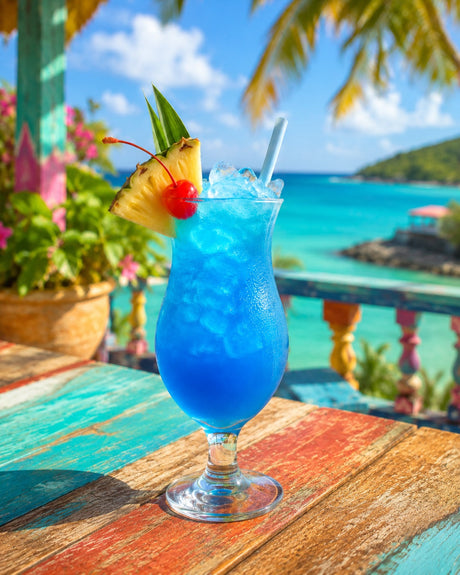 Blue Hawaiian Cocktail mit Ananas, Kirsche und Strohhalm auf karibischem Bartisch vor Meerblick