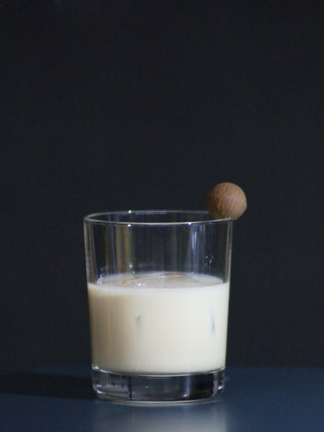 Nutty Irishman Cocktail in einem Glas mit Eiswürfeln, garniert mit einer Schokoladenkugel am Glasrand.
