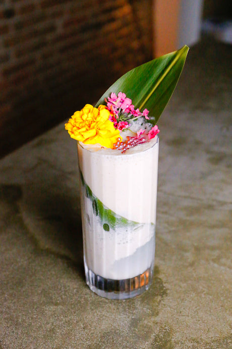 Margarita Strawberry Fresón Cocktail im Glas mit cremiger Schicht, Blüten und Blatt als Dekoration