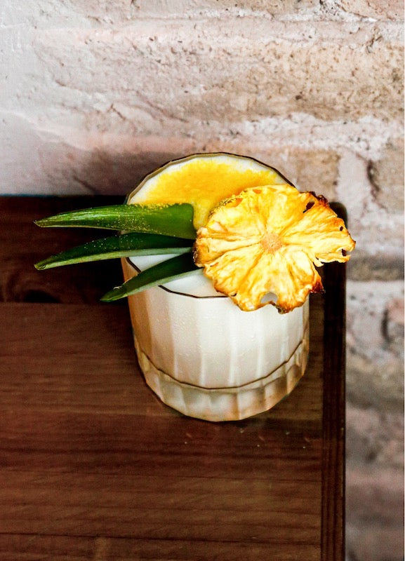 Mexican Monkey Fresón im Old Fashioned Glas, weiß-cremig, mit Ananasscheibe und Palmblatt-Deko