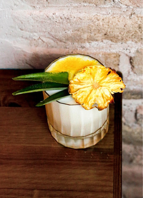 Mexican Monkey Fresón im Old Fashioned Glas, weiß-cremig, mit Ananasscheibe und Palmblatt-Deko