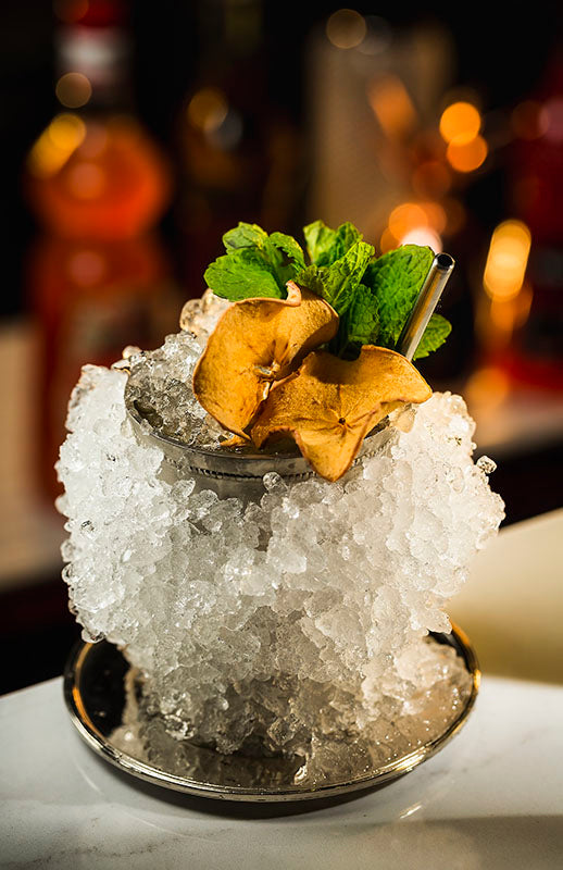 Pfirsich Julep im Silberbecher mit Crushed Eis, getrockneten Pfirsichscheiben und frischer Minze