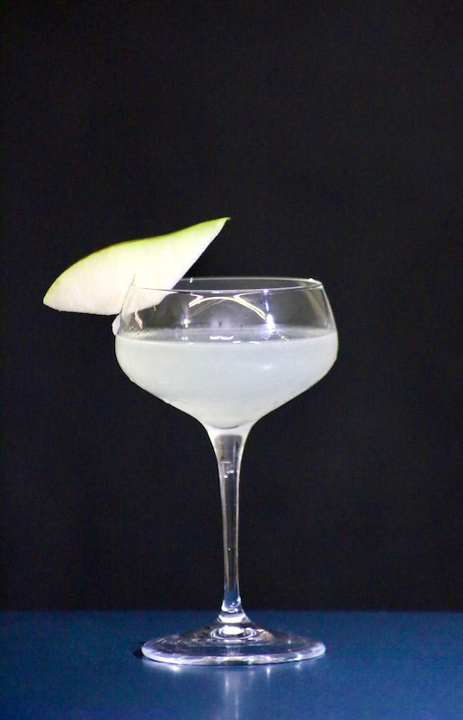 Cocktail Pear Daiquiri in einem eleganten Coupette-Glas, garniert mit einer frischen Birnenscheibe am Glasrand.