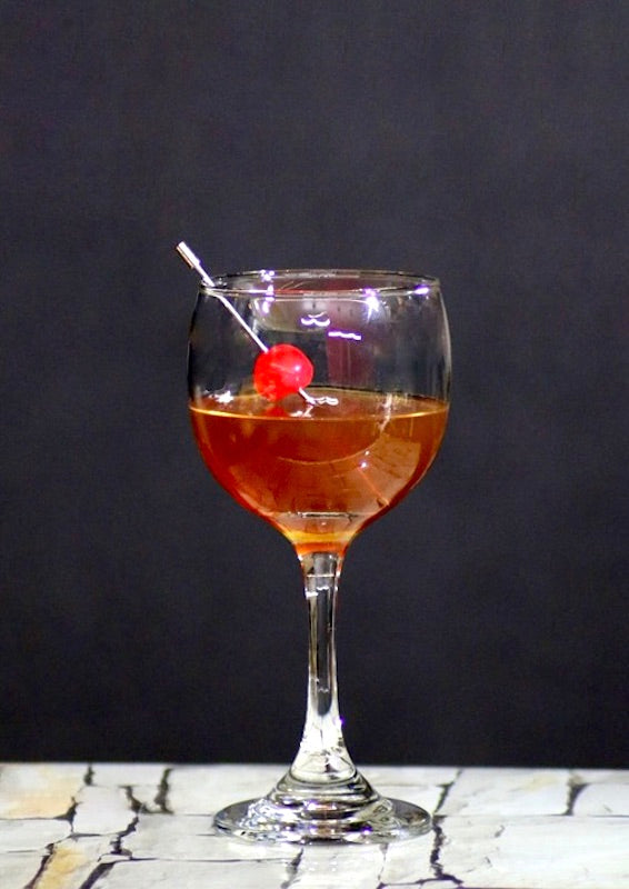 San Francisco Cocktail im Stielglas mit Cocktailkirsche vor dunklem Hintergrund