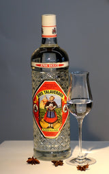 Anis Dulce Talaverana Anislikör Flasche neben Glas und Sternanis auf hellem Tisch