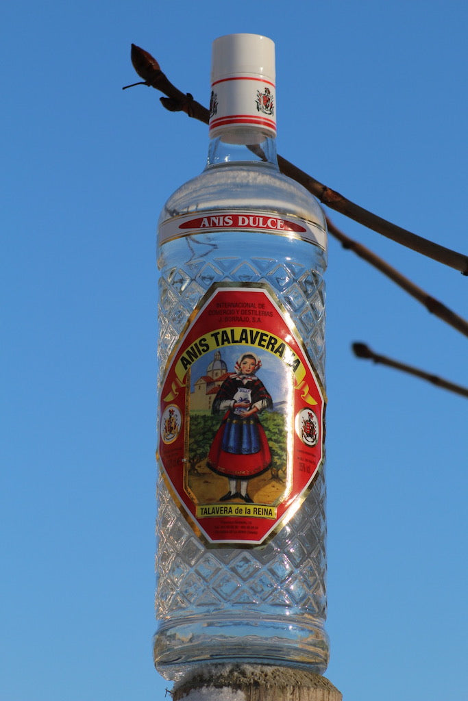 Anis Dulce Talaverana Anislikör Flasche auf Holzpfosten vor blauem Himmel