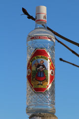 Anis Dulce Talaverana Anislikör Flasche auf Holzpfosten vor blauem Himmel