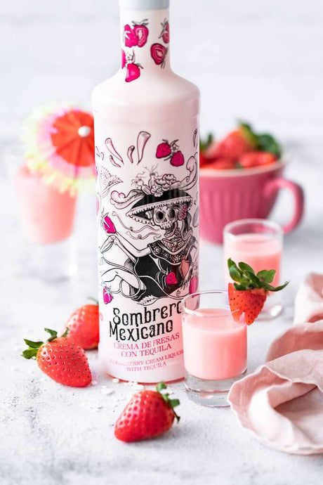 Sombrero Mexicano Erdbeer-Tequila-Likör mit verzierten Gläsern, frischen Erdbeeren und rosa Details auf hellem Untergrund.