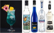 Blue Hawaii Cocktail Set: Drink im Hurricane-Glas mit Ananasscheibe und Blumen, neben Flaschen von Rum, Blue Curaçao, Vodka und Sirup.