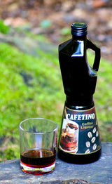 Cafetino Coffee Liqueur in Espressokanne-Flasche mit eingeschenktem Rocks Glas auf Holzuntergrund, grüner Hintergrund