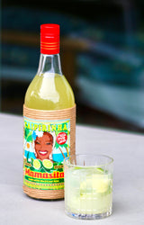 Mamasita Caipirinha Mix Flasche mit serviertem Caipirinha im Glas auf hellem Tisch