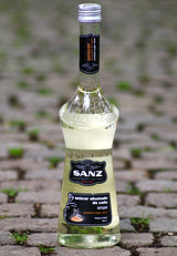 Flasche Sanz geräucherter Rohrzuckersirup auf Kopfsteinpflaster, mit schwarzem Etikett und stilvollem Design.