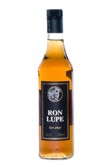 Rum Añejo Lupe in goldbrauner Farbe, in hoher Flasche mit schwarzem Etikett und markantem Schriftzug Ron Lupe.