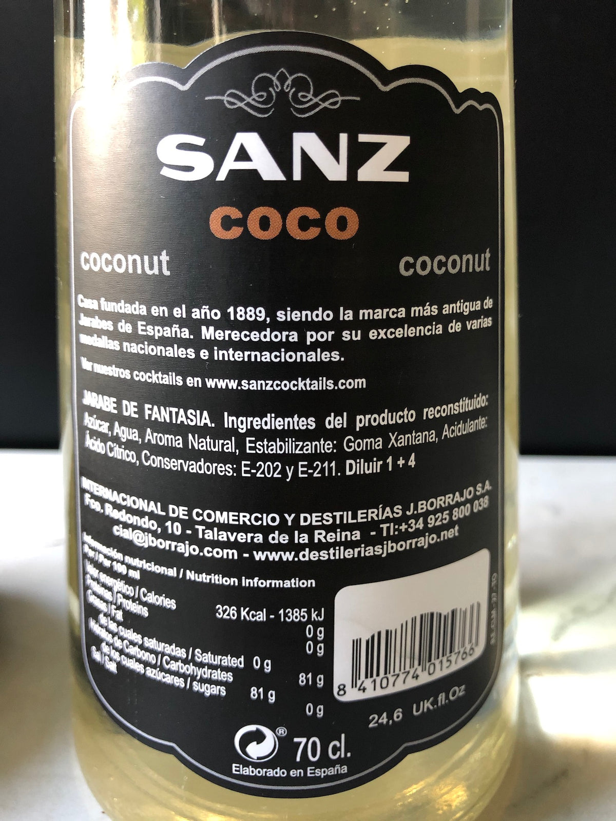 Nahaufnahme des Etiketts der Kokossirup-Sanz-Flasche mit Zutatenliste, Nährwertangaben, Barcode und Herstellerinformationen.