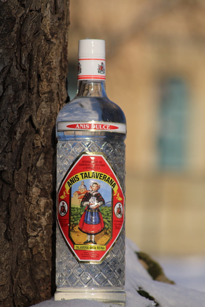 Anis Dulce Talaverana Anislikör Flasche neben Baumstamm auf Schnee