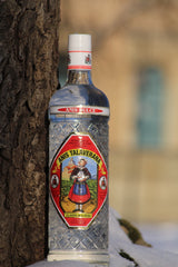 Anis Dulce Talaverana Anislikör Flasche neben Baumstamm auf Schnee