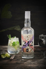 Rocky Island 242 White Rum Flasche neben Mojito mit Limette und Minze auf Holztisch