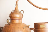 Kupferner Destillationsapparat von Lantern Rock Rum mit Rohrleitung und Manometer vor neutralem Hintergrund.