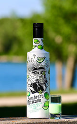 Flasche Sombrero Mexicano Melon Likör mit Tequila und grünem Shot im Glas, stehend vor See und grünem Hintergrund.